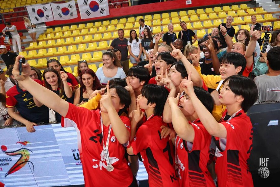 ▲ 북마케도니아 현지에서 한국을 응원한 팬들과 기념촬영하는 한국 청소년 여자 핸드볼 대표팀 ⓒIHF 홈페이지