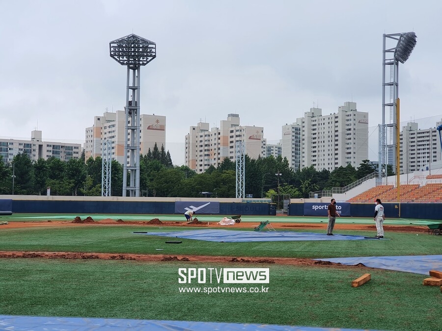 ▲ 그라운드 사정으로 11일 대통령배 일정을 치르지 못한 목동구장. 마운드 옆에선 대한야구소프트볼협회 박휘용 심판팀장(왼쪽)과 덕수고 정윤진 감독 등이 경기 진행 여부를 놓고 대화를 나누고 있다. ⓒ목동, 고봉준 기자