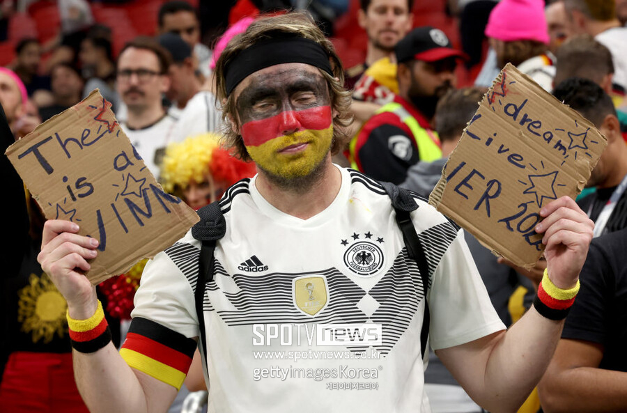 ▲ 2022 카타르 월드컵에서 독일이 16강 진출에 실패하자 한 독일 팬이 응원 문구가 적힌 종이를 찢고 있다.