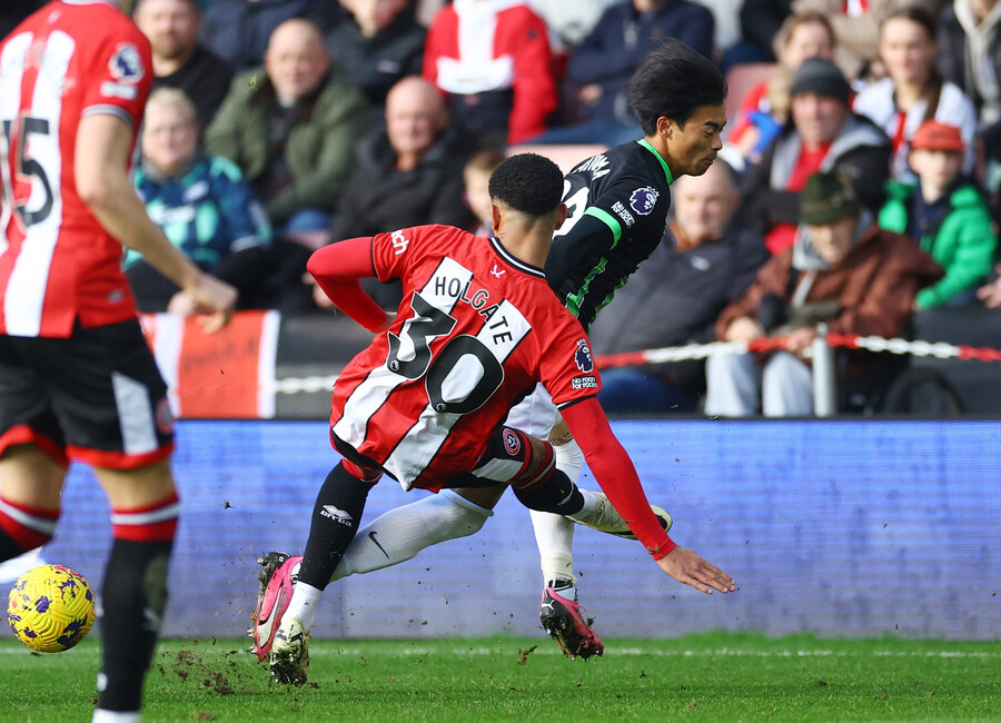 ▲ 셰필드 유나이티드 홀 게이트가 브라이턴 호브 알비언의 미토마 카오루에게 태클해 넘어트리는 장면. ⓒ연합뉴스/REUTERS